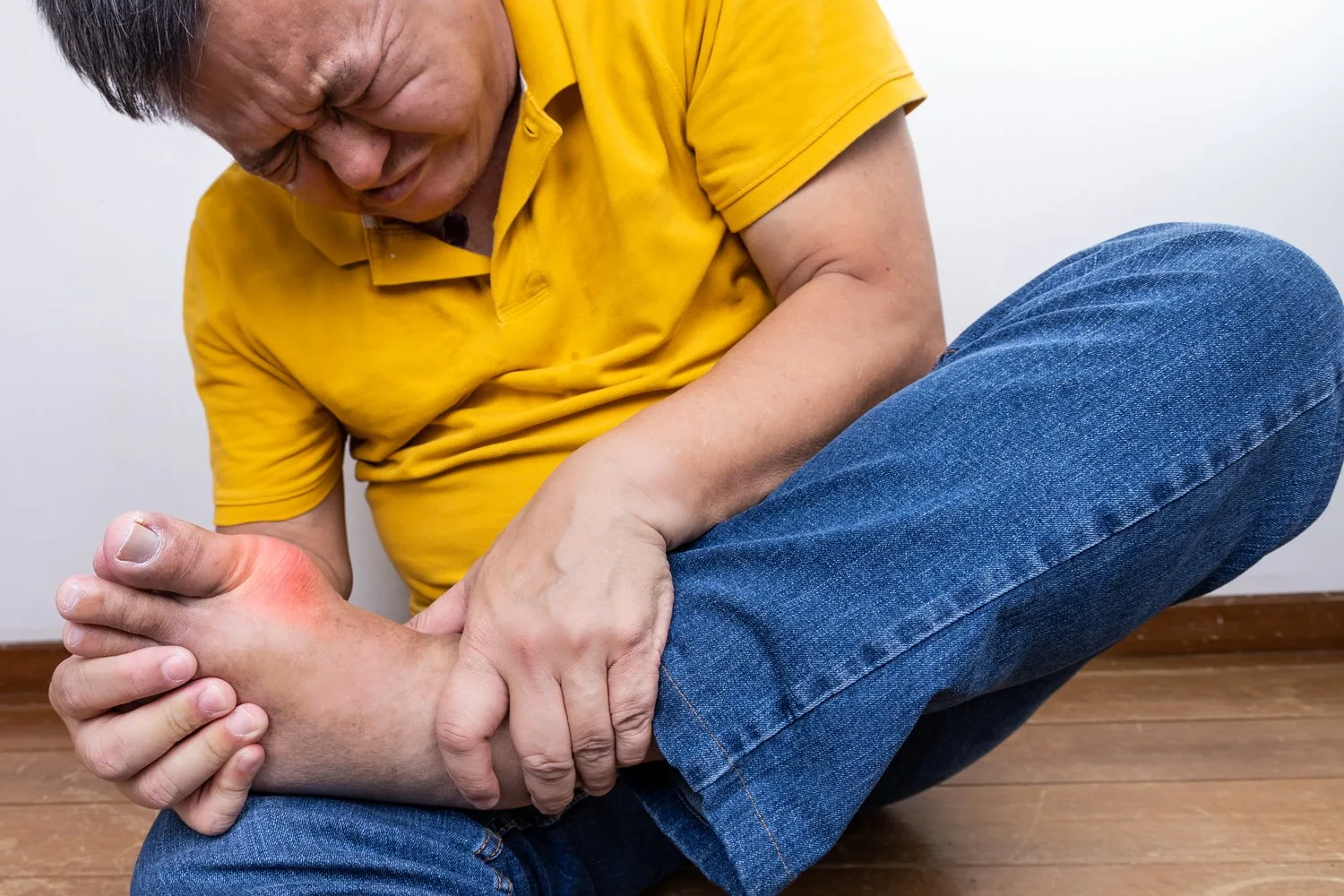 Man suffering with gout in his toe